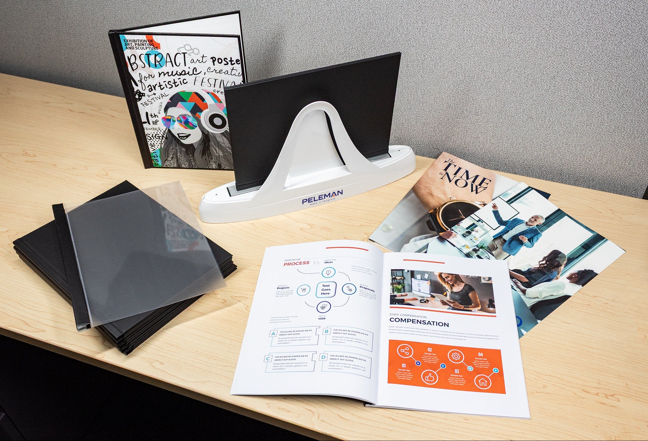 Desk with office supplies including a folder, brochures, and a computer monitor.