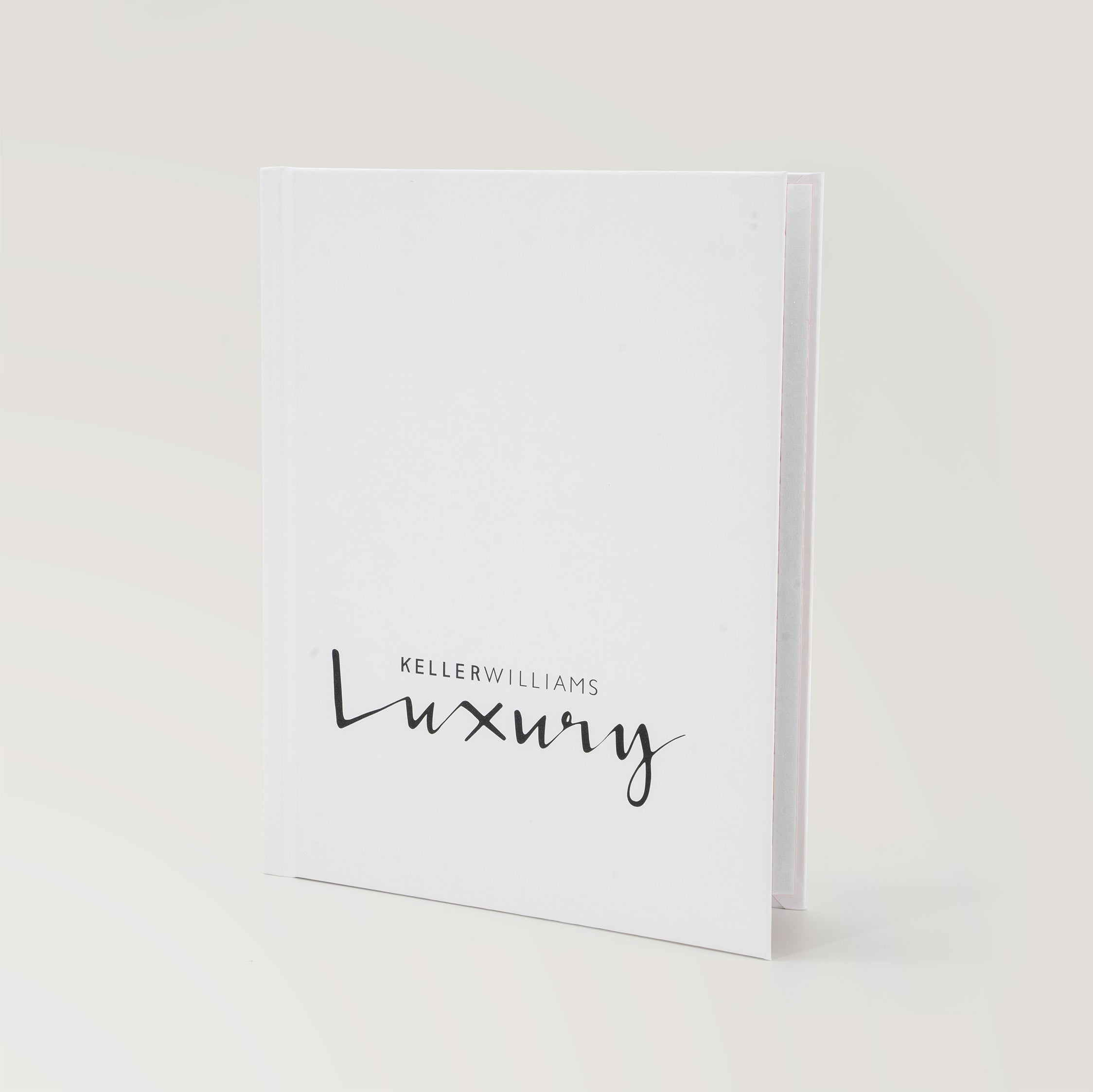 Keller Williams Luxury white hardcover book standing upright on a light background