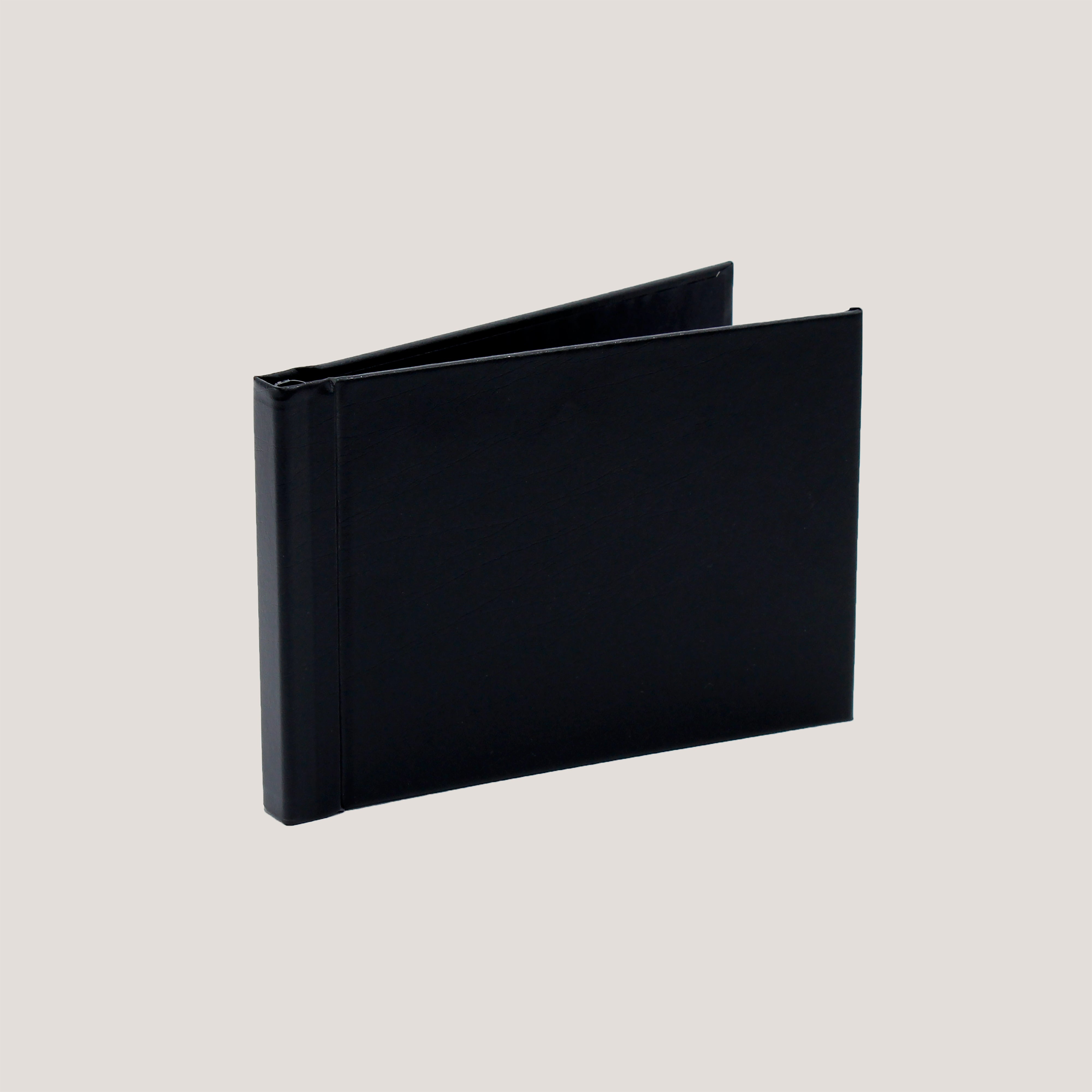 A black clamp binding photobook with a hard cover displayed open to show the binding mechanism.