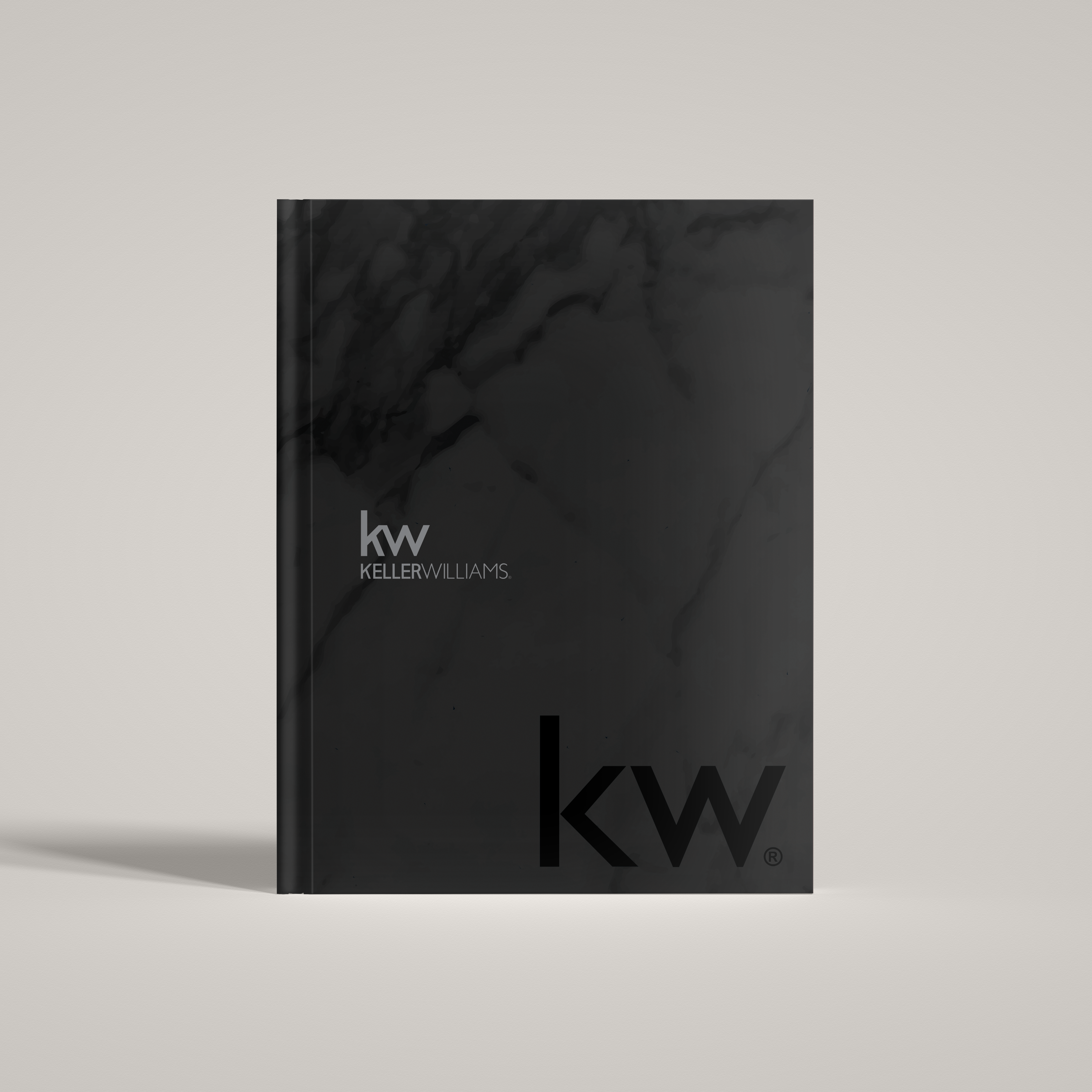 A black marble patterned hardcover notebook with the Keller Williams logo on the cover.
