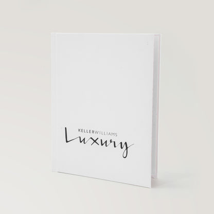 Keller Williams Luxury white hardcover book standing upright on a light background