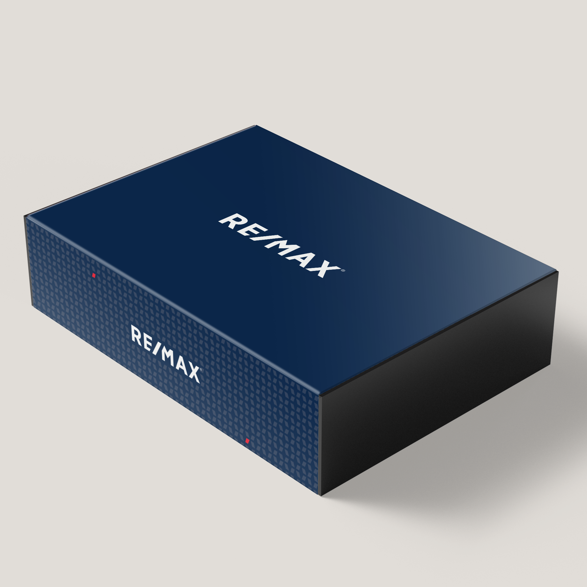 A large blue gift box with the RE/MAX logo on it, designed with a magnetic closure and patterned with white dots around the edges.
